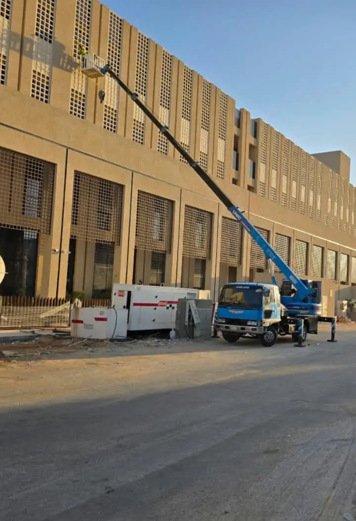 ونش رافعة على شاحنة بسلة رفع يعمل على واجهة مبنى تجاري